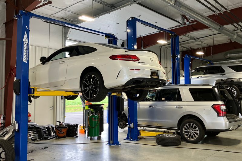 Vehicles on lifts inside the repair facility