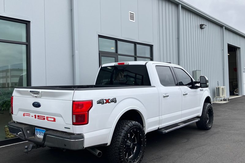 A white pickup beside the dealership building