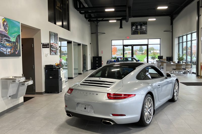A silver coupe and automotive artwork inside the Levant Motors showroom